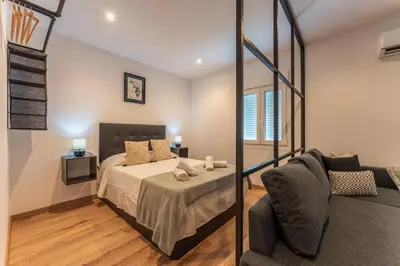 Cama o camas de una habitación en Apartamentos Turísticos Jardín del Albarregas