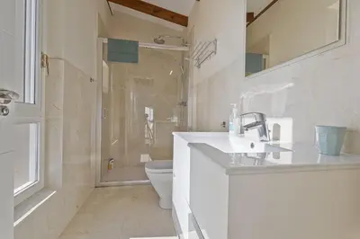 Un baño de Casa vacacional con piscina, pádel y BBQ