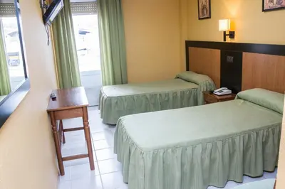 Cama o camas de una habitación en Hostal La Palmera
