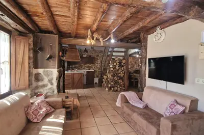 Una televisión o centro de entretenimiento en La Cantina casas rurales paredes